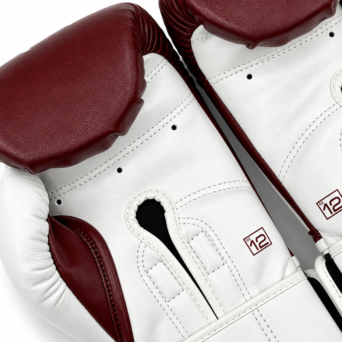 Close-up of fightlab boxing gloves in white leather with dark burgundy accents, showing the wrist closure and a small red '12' logo.