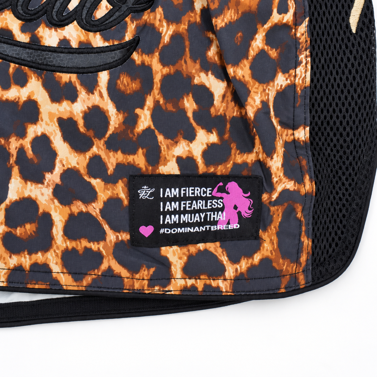 Close-up of aMiss Fightlab leopard print bag with black mesh side panel and a black patch that reads 'I AM FIERCE I AM FEARLESS I AM MUAY THA'I with a pink silhouette and '#DOMINANTBRED'.