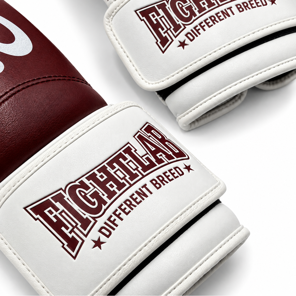 A close-up of a pair of boxing gloves in burgundy and white, featuring the 'FIGHTLAB' brand logo and 'DIFFERENT BREED' text on the wrist straps.