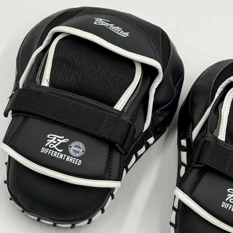 Black and white focus mitts with adjustable velcro straps, featuring the 'Big Musk' and 'Different Breed' branding on a clean white background.